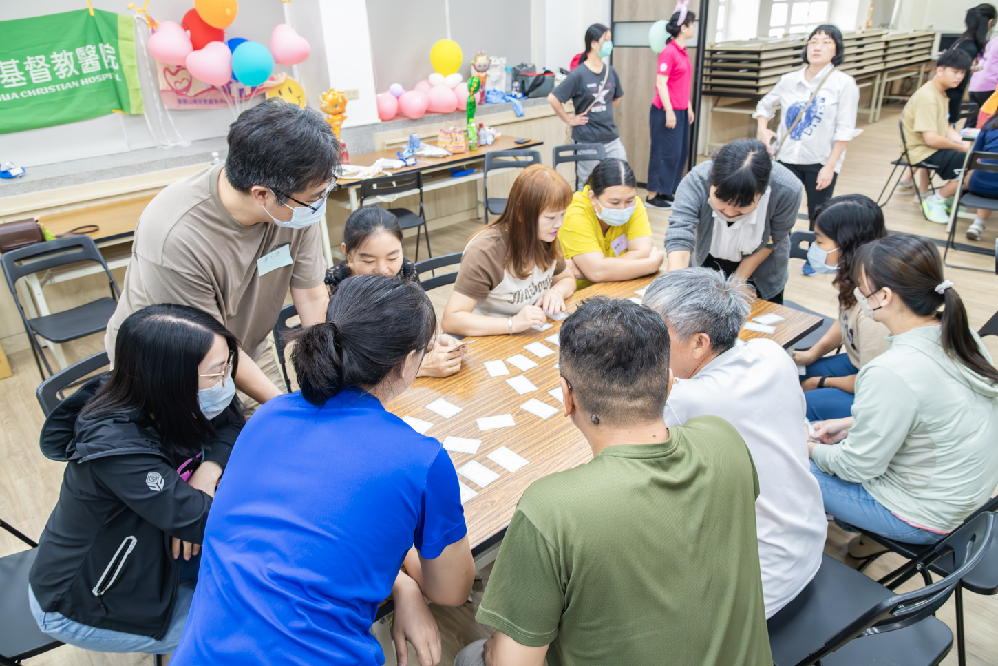 心理師透過牌卡活動，引導新住民親子互動，促進溝通與情感交流，現場氣氛溫馨熱鬧。(彰基提供)
